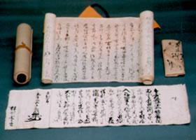 広げられている武井家文書と巻物状の武井家文書が並べられた写真
