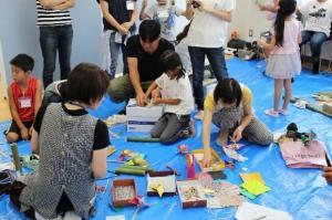 色紙や箱などを使い作品を作っている参加者の写真