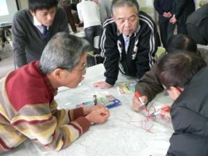 大きな紙地図に赤マジックで印をつけている地域安全対策部会の方々の写真