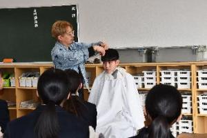 生徒の髪をカットしながらの授業