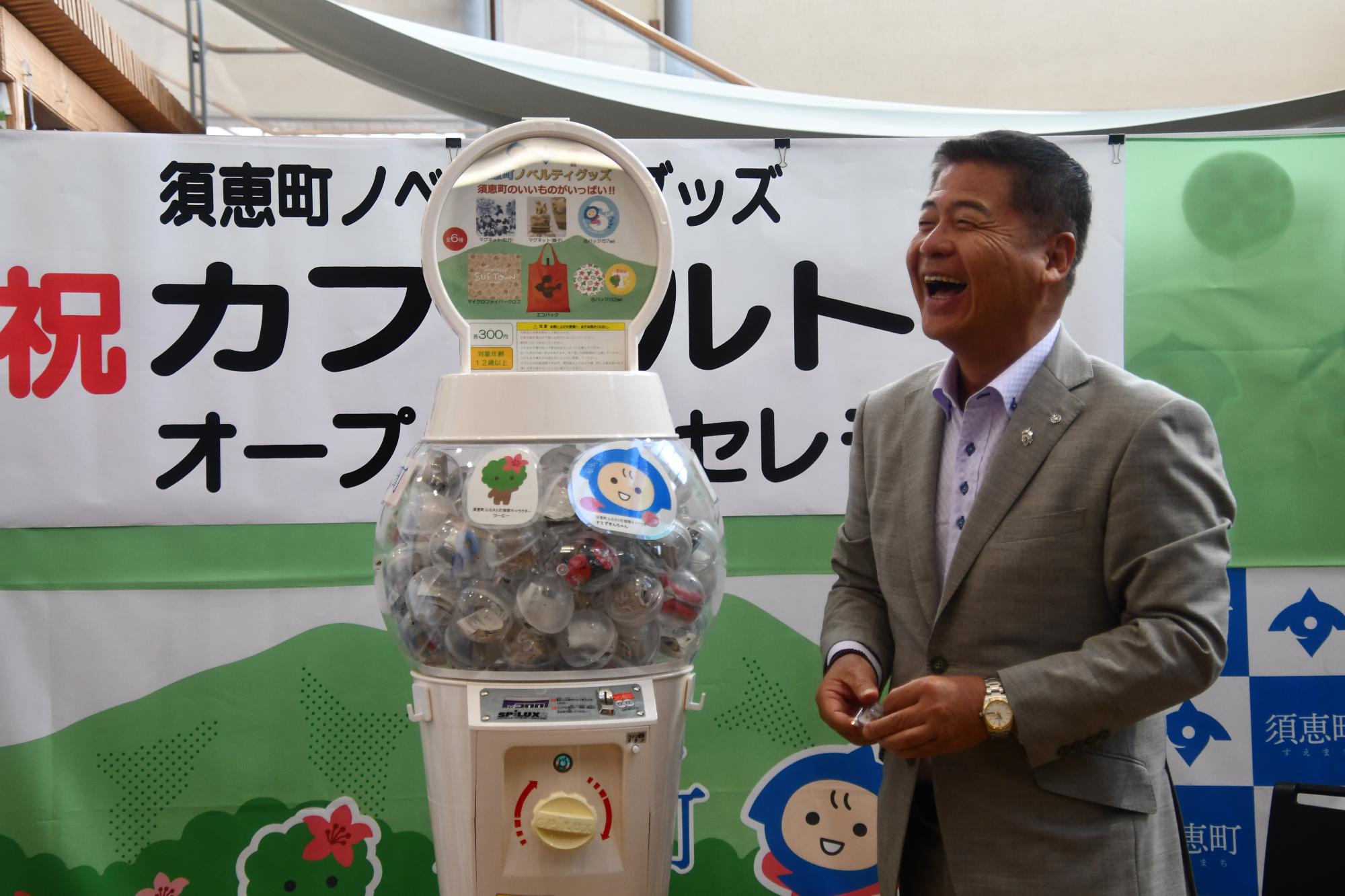 ノベルティグッズを披露する平松町長