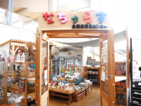 ドアの入り口に「なちゅらす 自然食普及センター」の文字があり、コーナーの中に自然食品の商品が並べてある写真