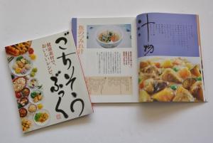 ごちそうぶっくのページを開いたところと色々な料理の写真が表紙になっているごちそうブックの写真
