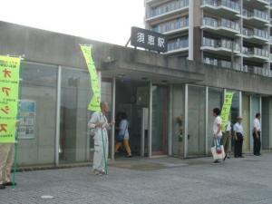 須恵駅前でオアシスと書かれたのぼり旗を持って立っている方々の写真